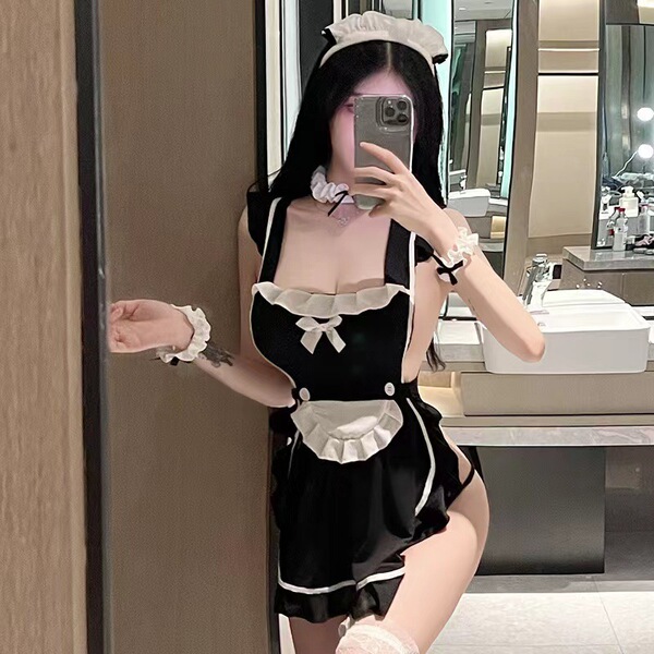 A woman poses in a bathroom wearing a black maid costume from plump fox, featuring lace apron and tied uniform details.