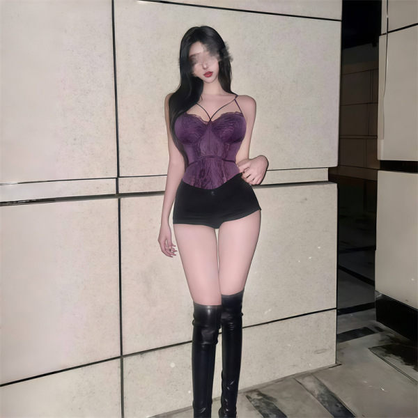 Curvy woman modeling purple lace lingerie set with thin bra and black shorts, paired with thigh-high boots.