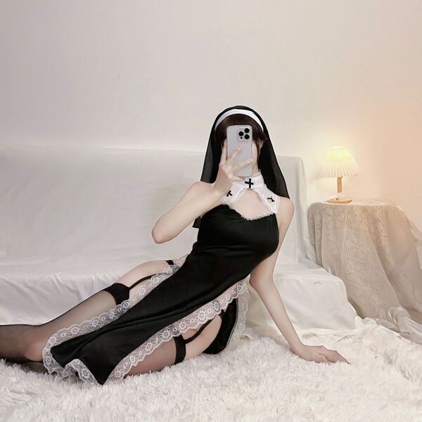 Model wearing black plus size punishment nun lingerie set with cut-outs and high slit, posing on bed for sexy role play.