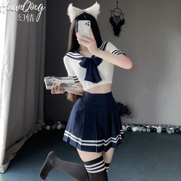 A person wearing a sailor uniform set, featuring a white crop top with blue accents, a navy pleated skirt, knee-high socks, a...