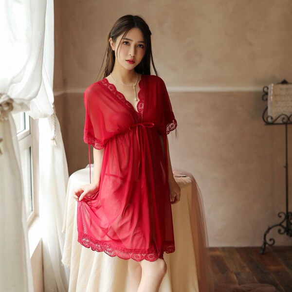 A woman models a plus-size sheer red lingerie set, featuring delicate lace details and a flowing design, perfect for sensual ...