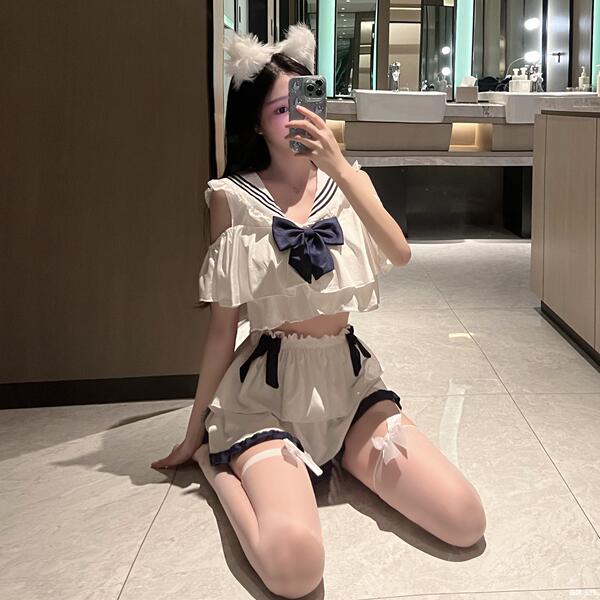A woman poses in a bathroom wearing a plus-size sailor-style lingerie set, featuring a sheer soft girl outfit with ruffled de...