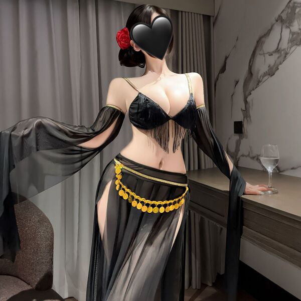 Woman wearing black plus size sensual lingerie set with gold coin belt, sheer sleeves, and fringe bra for elegant bedroom int...