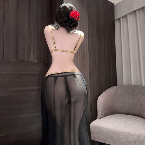 Woman wearing plus size sensual lingerie set with sheer black skirt and gold trim, elegant sleepwear for bedroom intimacy.