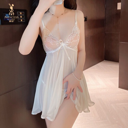 Woman wearing white lace sleepwear with deep v neckline and thin straps, featuring a bow detail at the front.