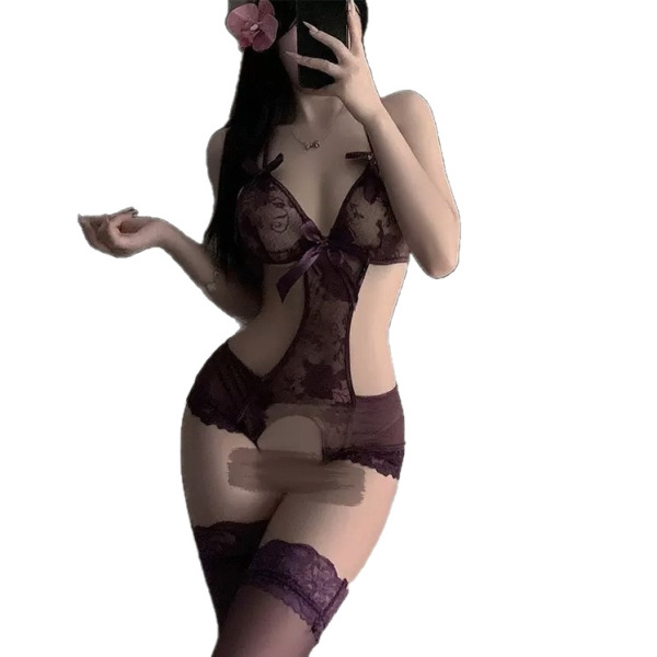 Woman wearing a plus size sheer purple lace bodysuit with open crotch, floral hair accessory, and thigh-high stockings.