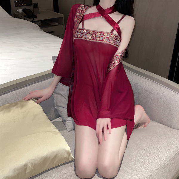 Woman wearing red sheer mesh hanfu-inspired lingerie set with corset dress and overlay top, kneeling on bed.