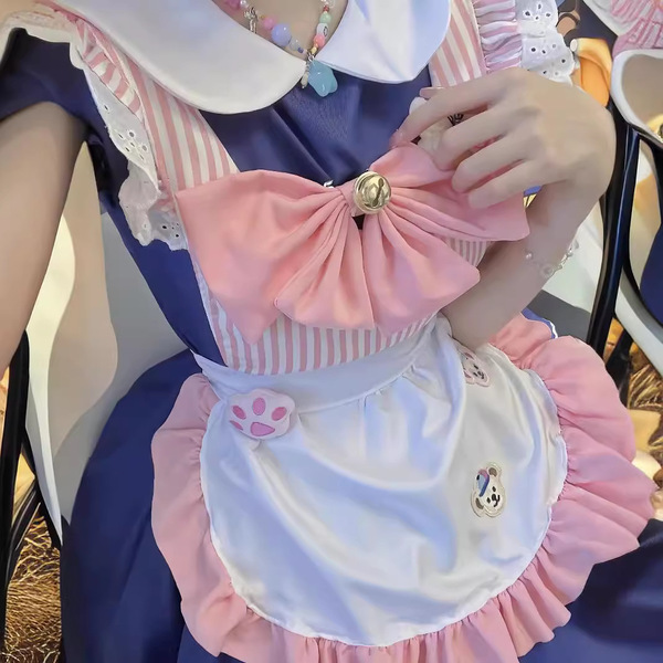 A detailed view of a cat-themed maid costume, featuring a pink bow, white apron with paw prints, and a striped dress, perfect...