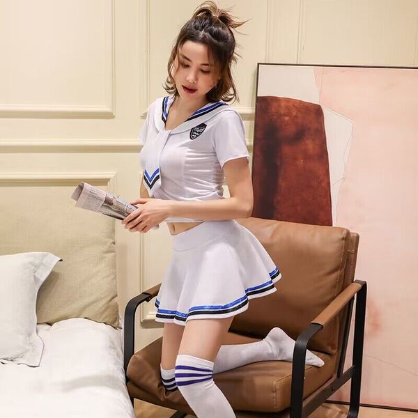 A stylish young woman models a cute sailor-style jk uniform set, featuring a white top with blue accents and matching skirt, ...
