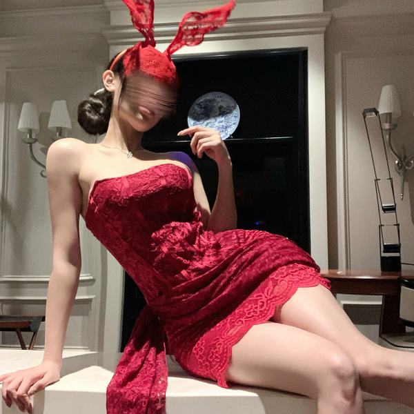 A woman poses elegantly in a red lace dress with bunny ears, showcasing a sheer bodycon mini skirt. the sexy modest style fea...