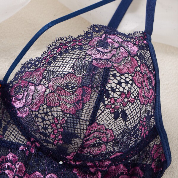 Close-up of pure & alluring lace sleep dress – ultra-thin sheer mesh sensual nightgown with pink floral embroidery on navy bl...
