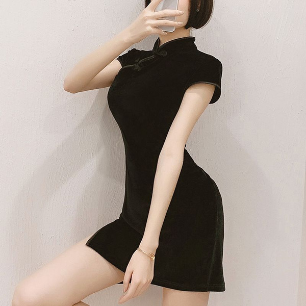 A woman poses in a black vintage-inspired qipao dress featuring side slits and a bodycon fit, perfect for modern elegance.