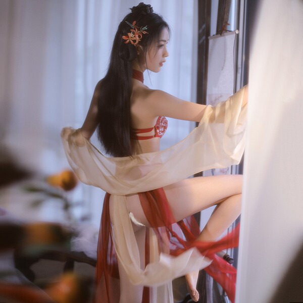A woman elegantly poses wearing a vintage chinese hanfu set, featuring a dunhuang flying phoenix embroidered halter bodice pa...