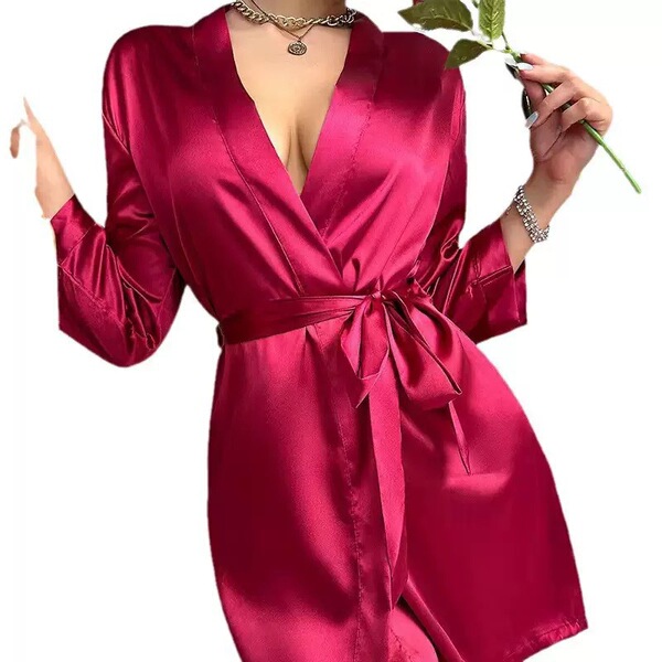 A woman wears a luxurious, deep red silk robe dress, featuring long sleeves and a tie belt. perfect for summer lounging and s...