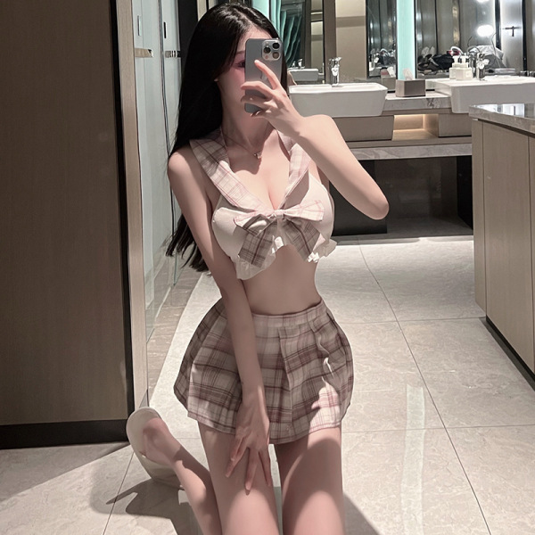 Woman in pink plaid jk sleepwear set with bow top and skirt, posing in bathroom mirror for sexy student roleplay lingerie loo...