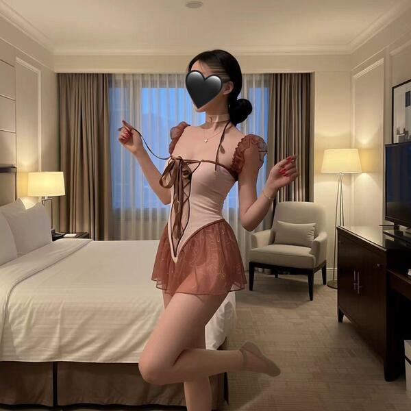 Woman in hotel room wearing pure & playful lingerie set — cute student-style open-crotch bodysuit with hook closure, no-remov...