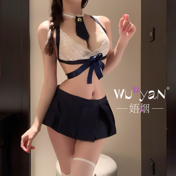 Woman modeling a white lace bra with navy ribbon and matching pleated skirt, part of the pure & playful lingerie set - seduct...