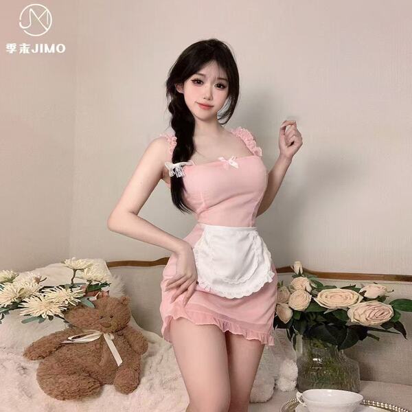A woman poses in a pink nurse-themed sleepwear set, featuring sheer fabric and lace details, perfect for a playful yet elegan...
