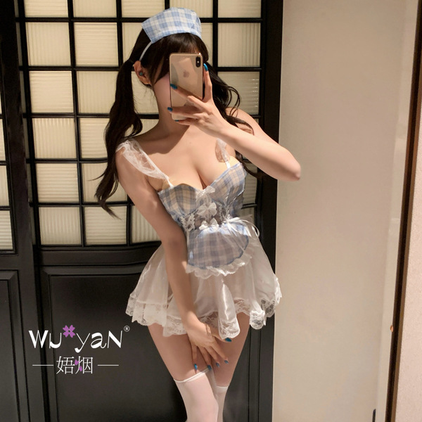 A woman poses in a maid-themed lingerie set, featuring a plaid top with lace details and a matching skirt, perfect for playfu...