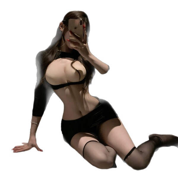 Woman in black lingerie set taking selfie, featuring sheer fabric and delicate lace trim on bra and shorts.