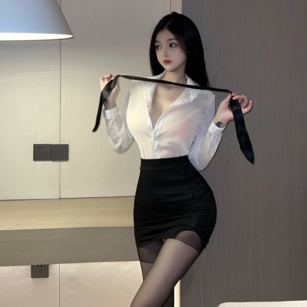 Woman in white sheer blouse and black skirt holding a tie, showcasing the pure & playful lingerie sleep set.