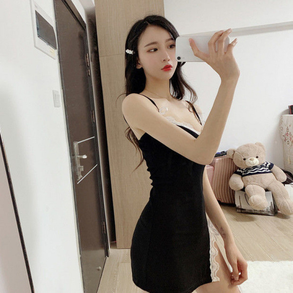 A woman poses with a teddy bear while wearing a black sheer sleep dress from the pure & playful lingerie collection, highligh...