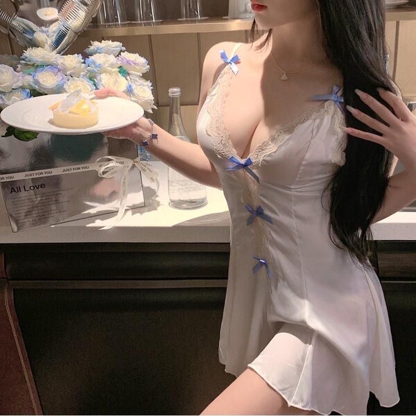Woman in white sheer babydoll sleep dress with blue bows, holding dessert plate. pure & playful lingerie sleep set.