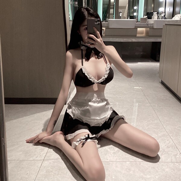 Woman posing in mirror wearing black and white maid lingerie set with lace trim, garter belt, and choker. pure & playful maid...