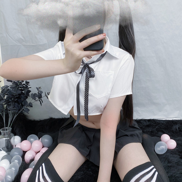 A stylish model showcases the pure & playful student-inspired lingerie set, featuring a white shirt with a bow-tie top and pl...