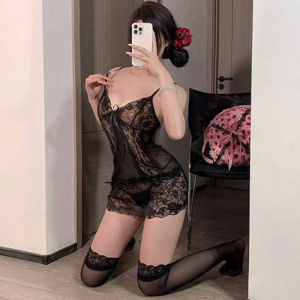 Woman kneeling in mirror selfie wearing black lace sleep dress with sheer babydoll design and adjustable straps.