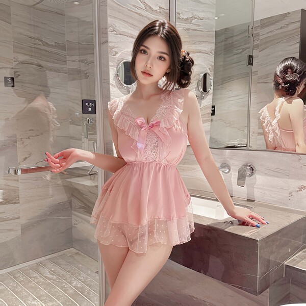 Woman in pink lace sleep dress with ruffles and bow, posing in marble bathroom. pure & seductive satin-blend nightgown with a...