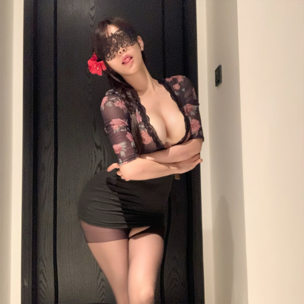 Woman in black floral lingerie set with lace mask and red flower, showcasing elegant yet sensual sleepwear design.