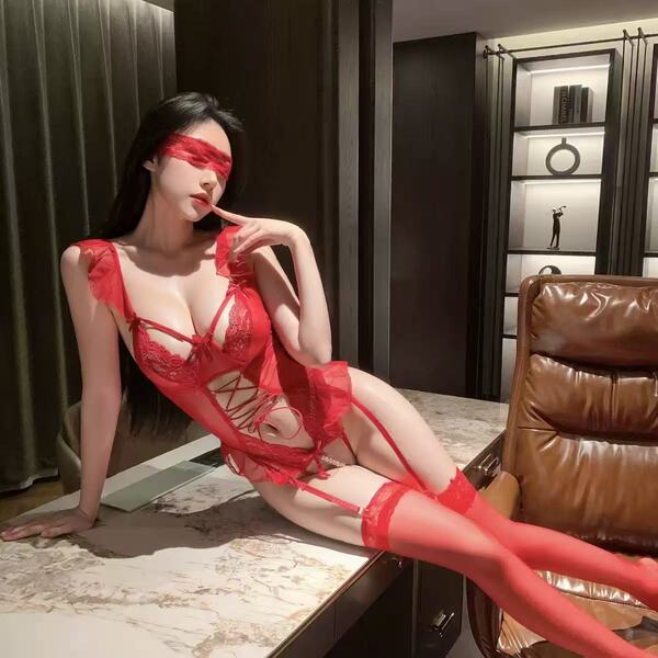 A woman poses elegantly in a luxurious red lace lingerie set, featuring intricate designs and stockings, perfect for intimate...
