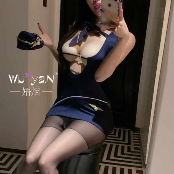 Woman in mirror selfie wearing navy blue airline-themed lingerie set with skirt, sheer stockings, and matching hat.