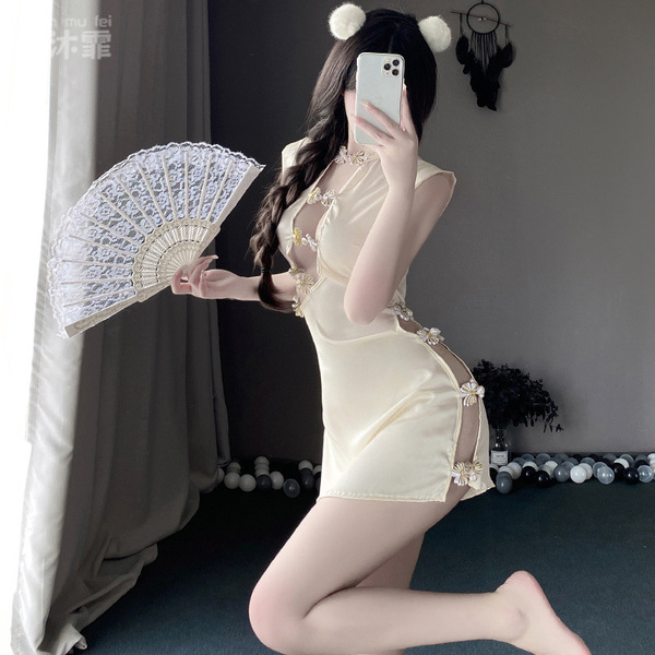 A woman poses with a fan, wearing a cream-colored lace nightgown featuring floral details and a sheer design, embodying a cla...