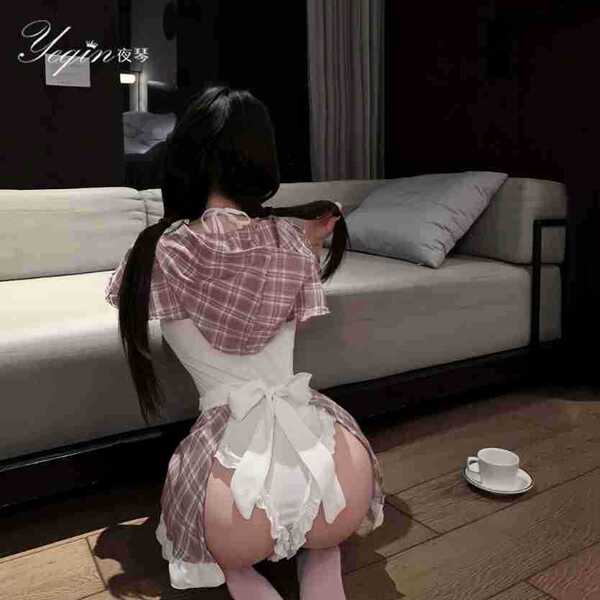 Woman in pink plaid maid costume with white apron, kneeling on wooden floor beside sofa, showcasing premium pure & seductive ...