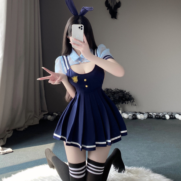 A person wearing a navy blue school uniform-style dress with white trim, featuring a pleated skirt, bunny ears, and a badge e...