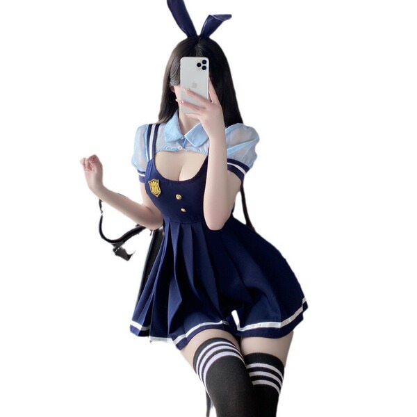 A person wearing a navy blue school uniform-style dress with white trimmings, bunny ears, and suspenders. the outfit includes...