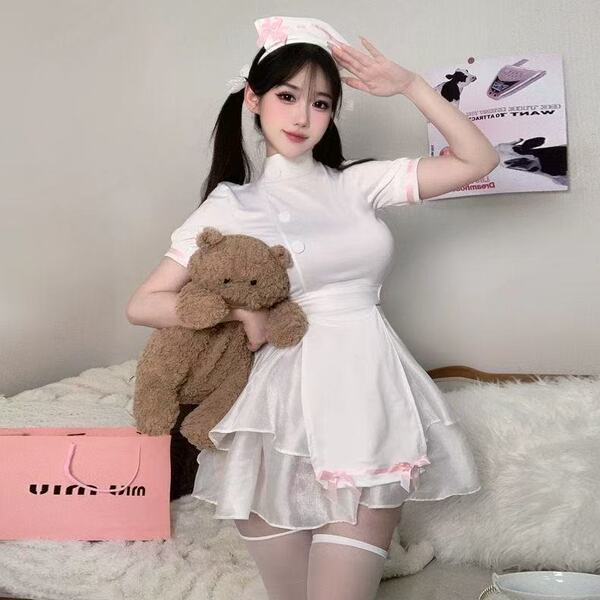 A person wearing a white nurse costume set, featuring lace details, high-slit design, and summer-ready white mesh fabric, hol...
