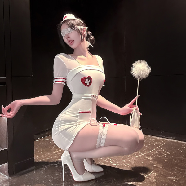 Woman in white pure temptation nurse costume lingerie set with red cross, blindfold, and feather duster posing seductively.