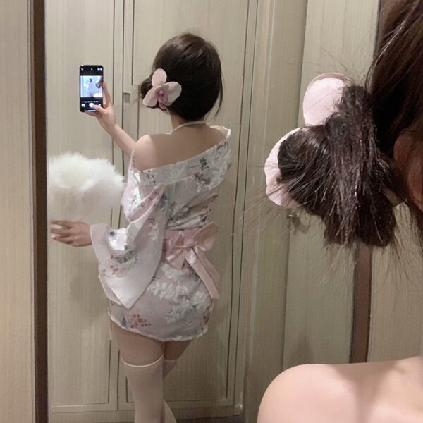 A woman models a delicate japanese-inspired kimono-style sleepwear set, featuring floral patterns, soft pink accents, and ele...