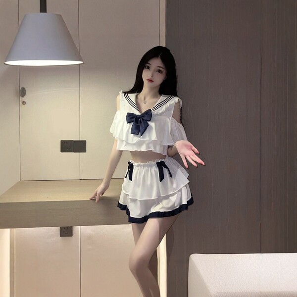 A woman poses in a navy collar bow skirt student lingerie set, featuring ruffled details and a playful design, perfect for fe...