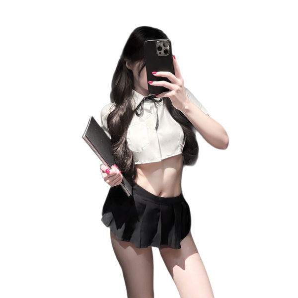 A woman poses with a phone, wearing a white crop top and black pleated skirt, holding a clutch. the outfit features a schoolg...