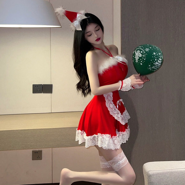 A woman poses wearing a festive christmas-themed sleepwear outfit, featuring a red dress with white lace trimmings and a sant...