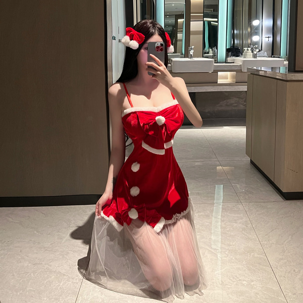 A woman poses in a festive red dress with white accents, resembling a santa hat, capturing herself in a mirror. the outfit fe...