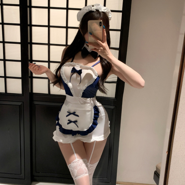 Woman wearing pure & tempting lingerie set – a white and navy maid-style outfit with apron, bow tie, garters, and lace stocki...