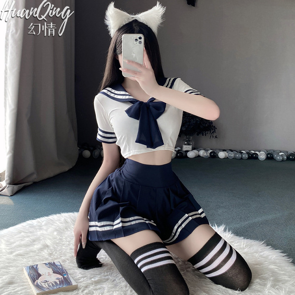 A person wearing a schoolgirl uniform set, featuring a sailor-style top with a bow tie, pleated skirt, knee-high socks, and c...