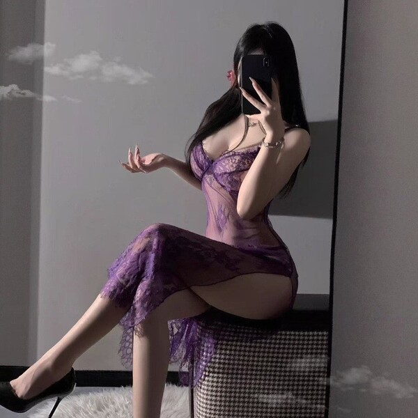 Woman wearing purple lace lingerie set with sheer straps, high slit, and uniform-inspired design, posing in mirror selfie.