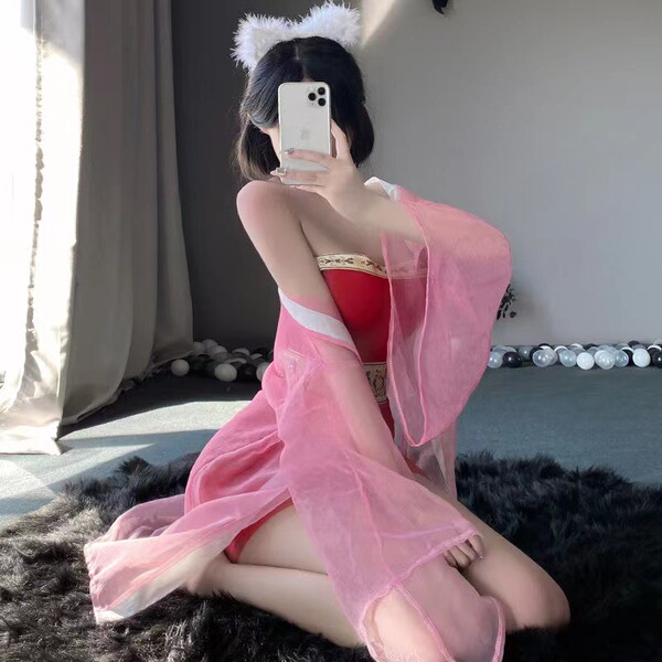A woman poses with cat ears, wearing a pink qiaoduo hanfu-inspired bodysuit and skirt, embodying a fox spirit design. the set...