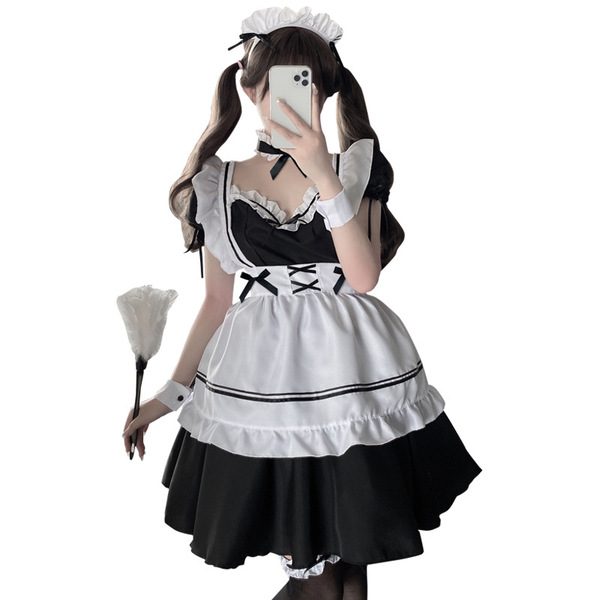 A woman poses in a black and white maid costume, featuring lace details and an adjustable strap design, holding a feathered f...